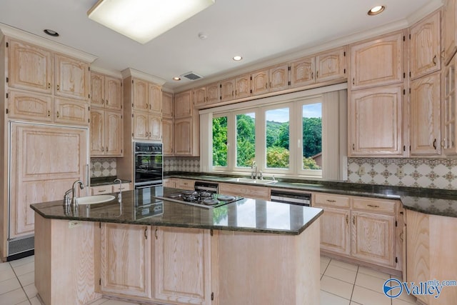 kitchen featuring light brown cabinets and a sink