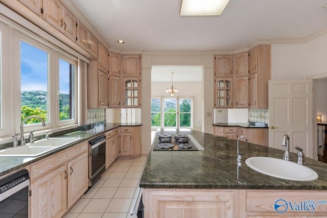 kitchen with stovetop, black dishwasher, light brown cabinetry, and a sink