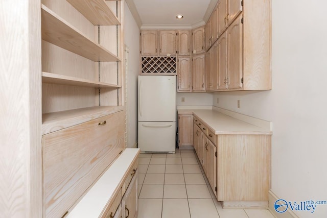 kitchen with light tile patterned floors, open shelves, light brown cabinets, light countertops, and freestanding refrigerator