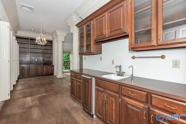 kitchen with ornate columns, a chandelier, a sink, visible vents, and crown molding