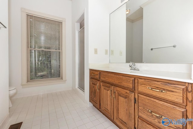 bathroom with vanity, tile patterned floors, toilet, visible vents, and a shower with door