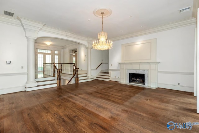 unfurnished living room with visible vents, ornamental molding, and wood finished floors