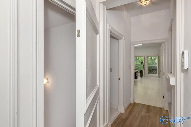 corridor with wood finished floors and baseboards