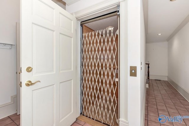 hallway with light tile patterned floors, recessed lighting, elevator, and baseboards