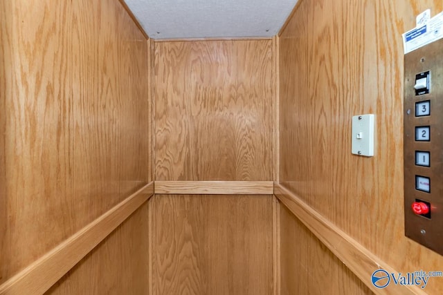 details with a textured ceiling and elevator