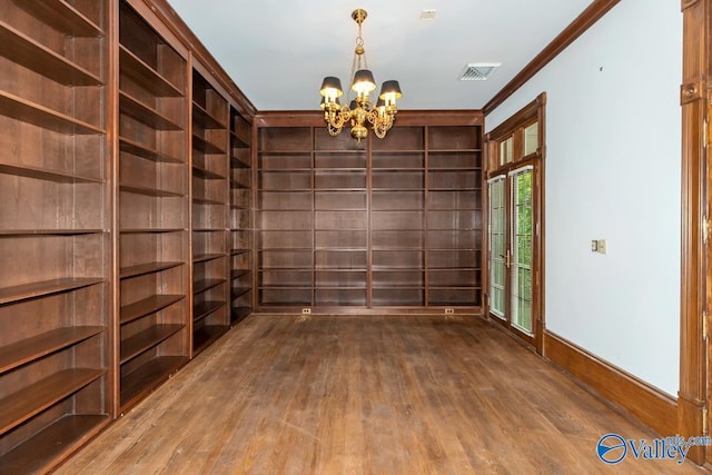 interior space with a chandelier, crown molding, visible vents, baseboards, and wood finished floors