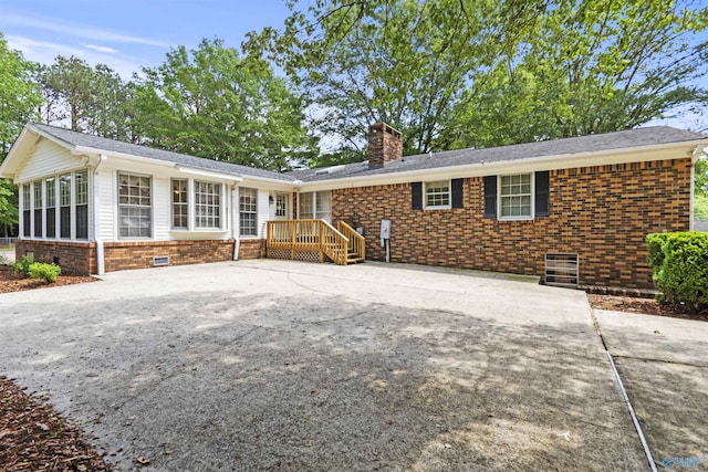 1025 Berkley Rd, Arab, AL 35016 - rear view of property featuring brick siding, a chimney, driveway, a sunroom, and crawl space