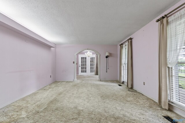 1025 Berkley Rd, Arab, AL 35016 - carpeted spare room featuring a chandelier, arched walkways, and a textured ceiling