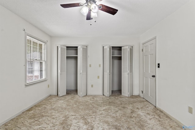 1025 Berkley Rd, Arab, AL 35016 - unfurnished bedroom featuring light carpet, two closets, a ceiling fan, baseboards, and a textured ceiling