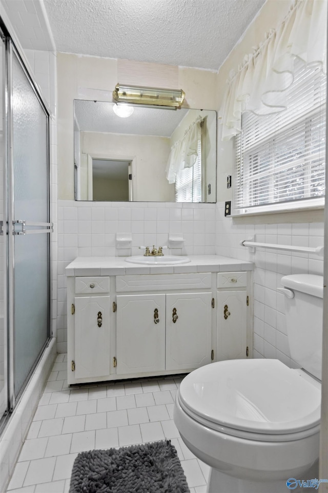 1025 Berkley Rd, Arab, AL 35016 - bathroom featuring toilet, tile walls, a shower stall, a textured ceiling, and tile patterned flooring