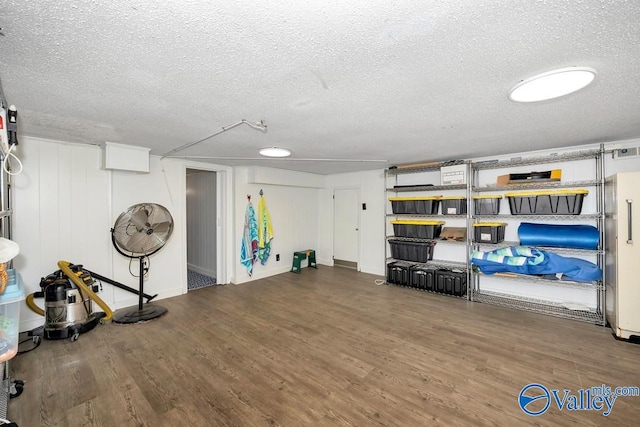 interior space with a textured ceiling and hardwood / wood-style floors