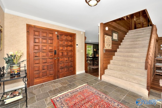 entryway with dark wood-type flooring and ornamental molding