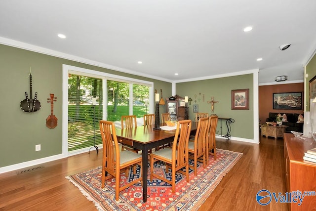 dining space featuring wood-type flooring and ornamental molding