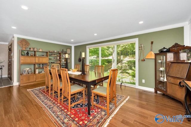 dining room featuring hardwood / wood-style flooring and crown molding