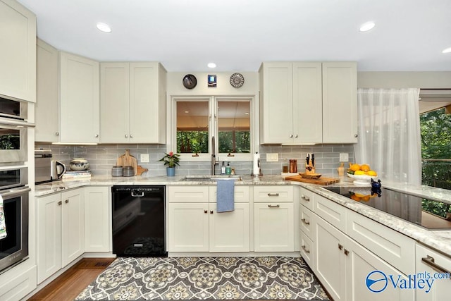 kitchen with backsplash, black appliances, and a wealth of natural light