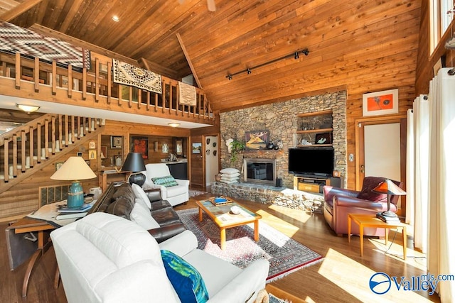 living room featuring rail lighting, wood ceiling, a fireplace, wood-type flooring, and high vaulted ceiling