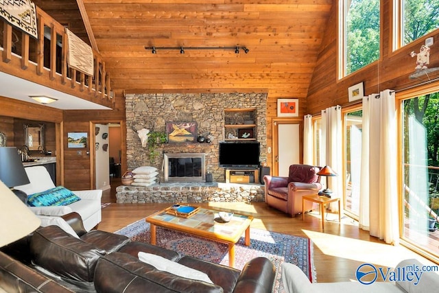 living room featuring built in features, wood ceiling, a stone fireplace, high vaulted ceiling, and wood-type flooring