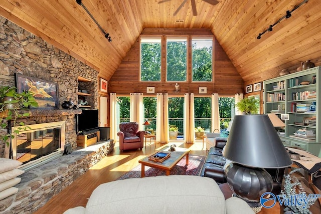 living room featuring wood ceiling, high vaulted ceiling, a fireplace, and hardwood / wood-style floors