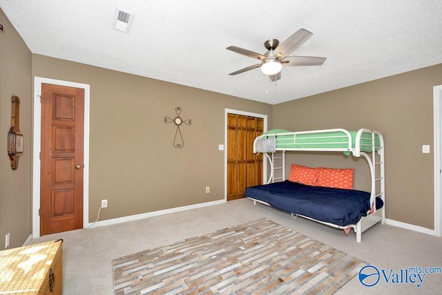 bedroom with a textured ceiling, a closet, carpet flooring, and ceiling fan