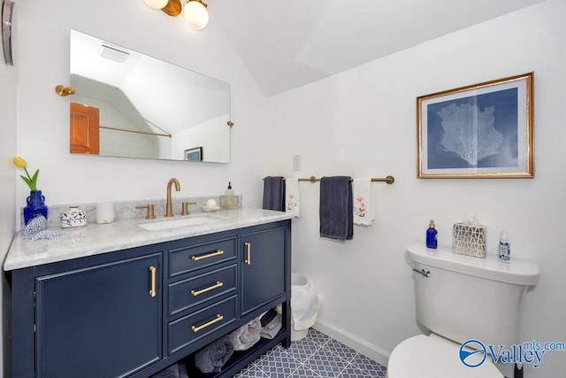 bathroom with vanity, lofted ceiling, tile patterned flooring, and toilet