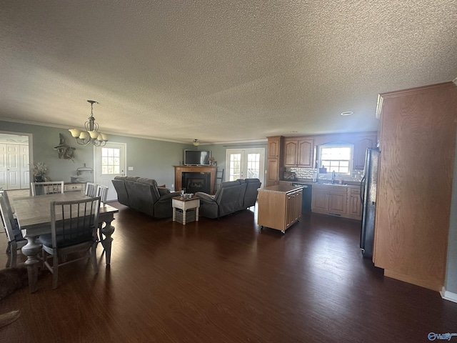 2415 Ruth Rd, Arab, AL 35016 - living room with ornamental molding, a textured ceiling, dark wood-style floors, an inviting chandelier, and a fireplace