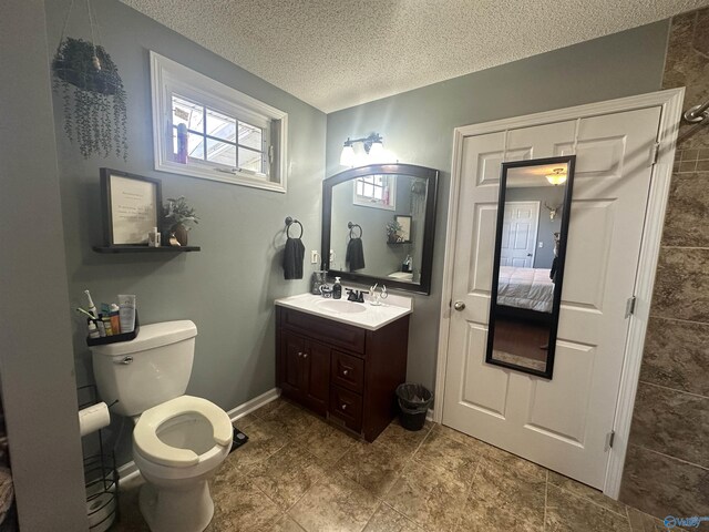 2415 Ruth Rd, Arab, AL 35016 - bathroom with baseboards, toilet, vanity, a textured ceiling, and ensuite bath