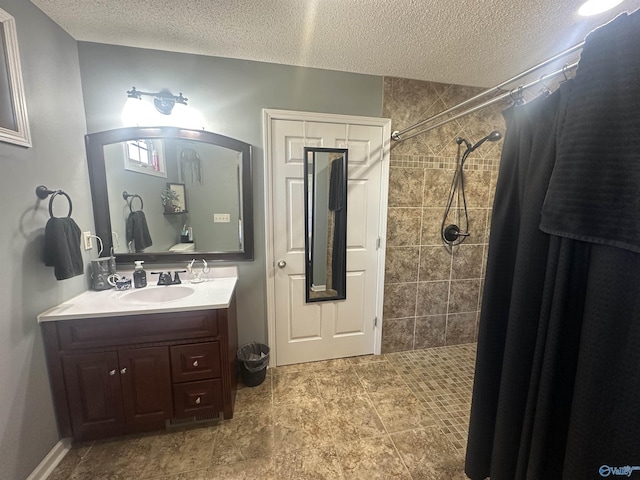 2415 Ruth Rd, Arab, AL 35016 - bathroom with a textured ceiling, tiled shower, and vanity