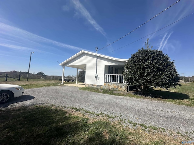 2415 Ruth Rd, Arab, AL 35016 - view of side of home featuring a carport, a porch, and gravel driveway