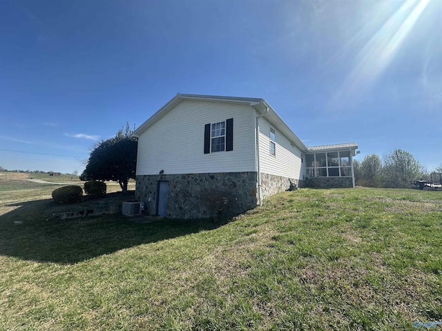 2415 Ruth Rd, Arab, AL 35016 - view of side of home with central AC unit, a lawn, and a sunroom