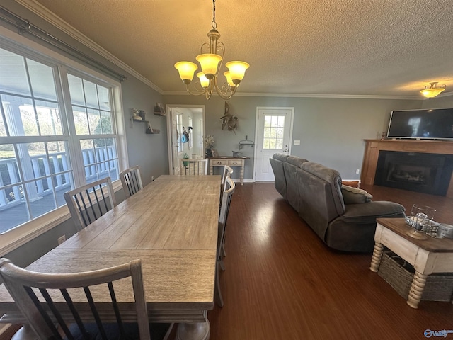 2415 Ruth Rd, Arab, AL 35016 - dining room featuring dark wood-type flooring, a notable chandelier, a textured ceiling, a fireplace, and crown molding