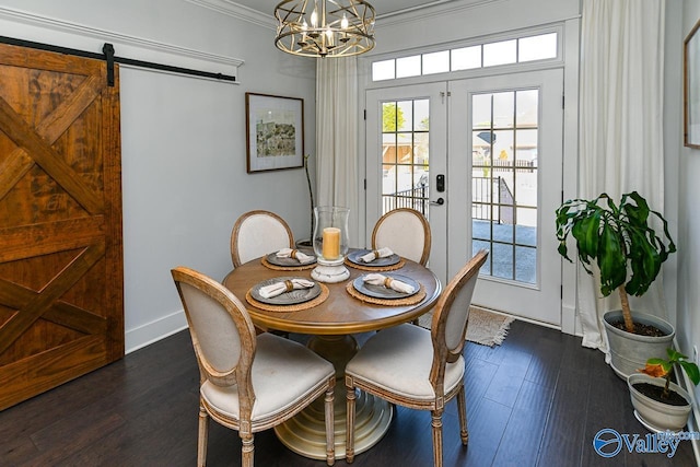 dining room with crown molding, a barn door, dark wood-type flooring, an inviting chandelier, and french doors