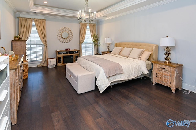 bedroom featuring dark hardwood / wood-style flooring, ornamental molding, a raised ceiling, and a chandelier