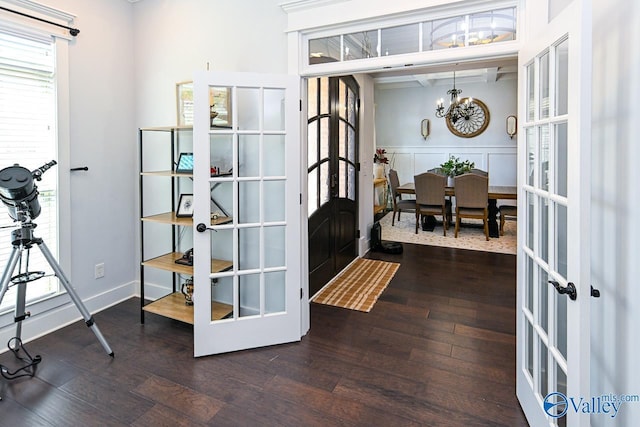 interior space with dark hardwood / wood-style floors, a chandelier, and french doors