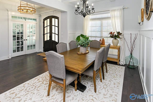 dining space with ornamental molding, an inviting chandelier, and french doors