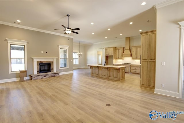13888 Mallard Dr, Madison, AL 35756 - kitchen featuring custom range hood, open floor plan, crown molding, a stone fireplace, and a ceiling fan