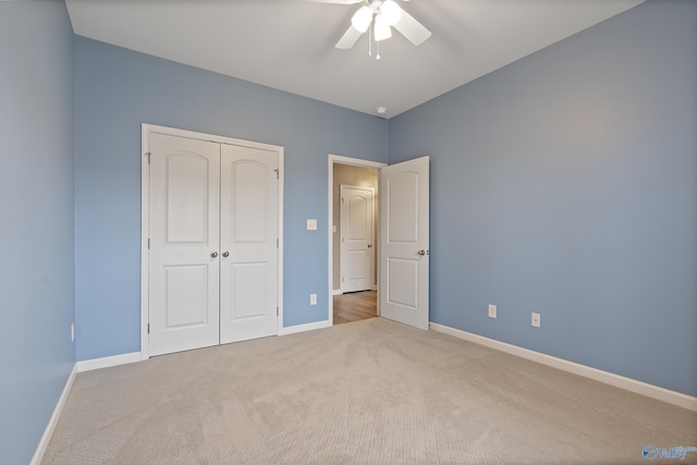 unfurnished bedroom with ceiling fan, light carpet, and a closet