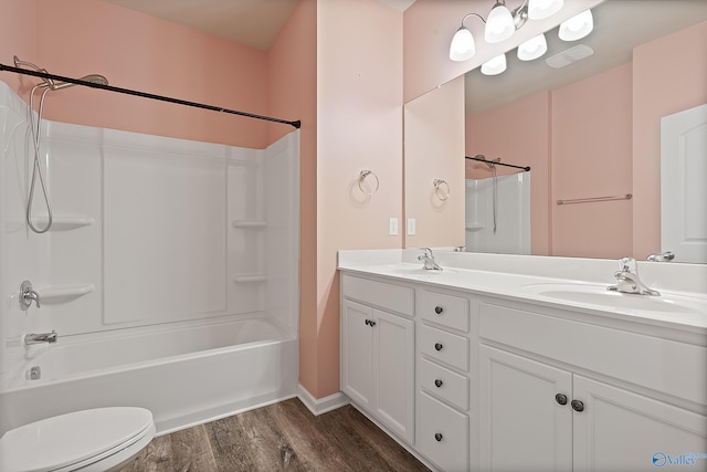 full bathroom with hardwood / wood-style floors, vanity, toilet, and washtub / shower combination