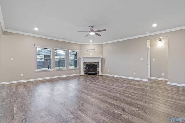 unfurnished living room featuring a stone fireplace, wood-type flooring, and ornamental molding