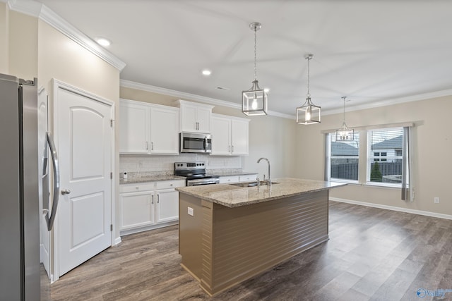 kitchen featuring a center island with sink, sink, hanging light fixtures, white cabinetry, and stainless steel appliances