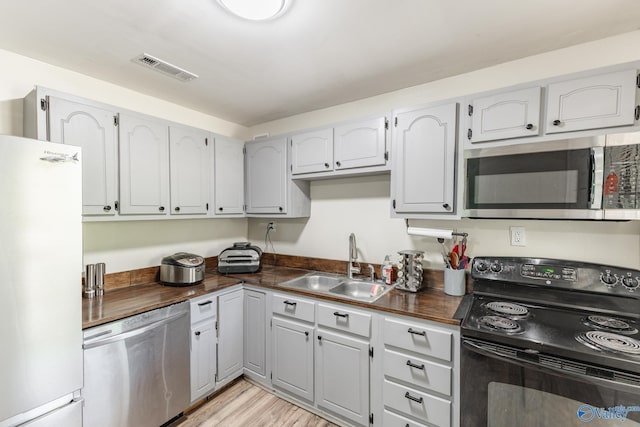 1101 5th Ave SW, Decatur, AL 35601 - kitchen featuring stainless steel appliances, a sink, butcher block countertops, and light wood finished floors