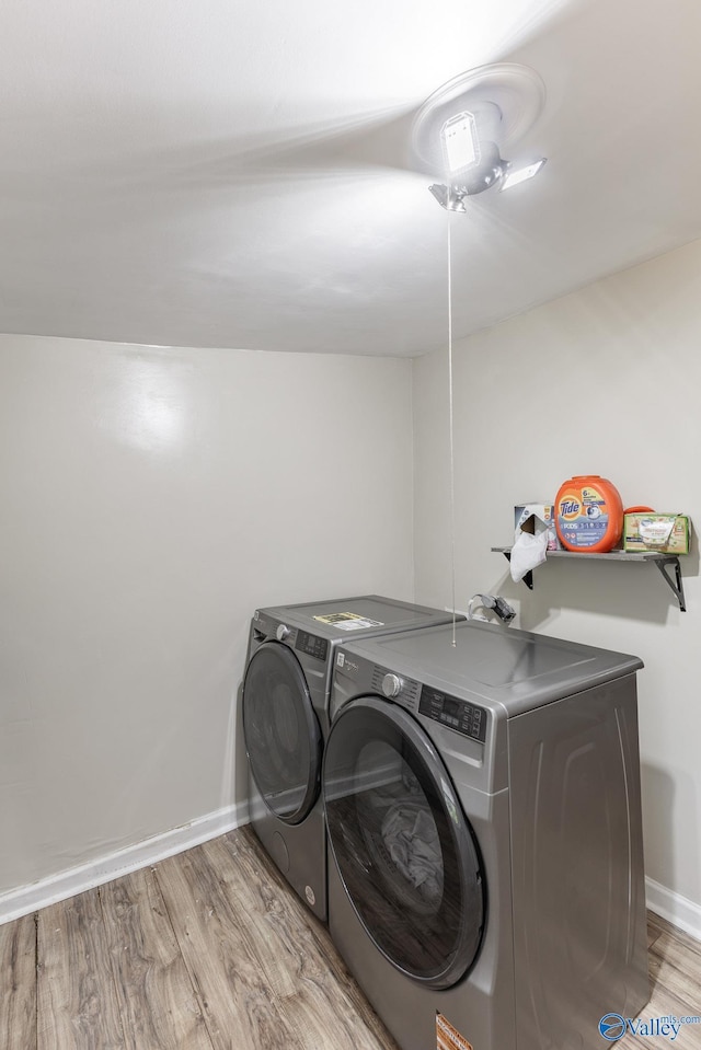 1101 5th Ave SW, Decatur, AL 35601 - laundry room featuring independent washer and dryer, light wood-type flooring, and baseboards
