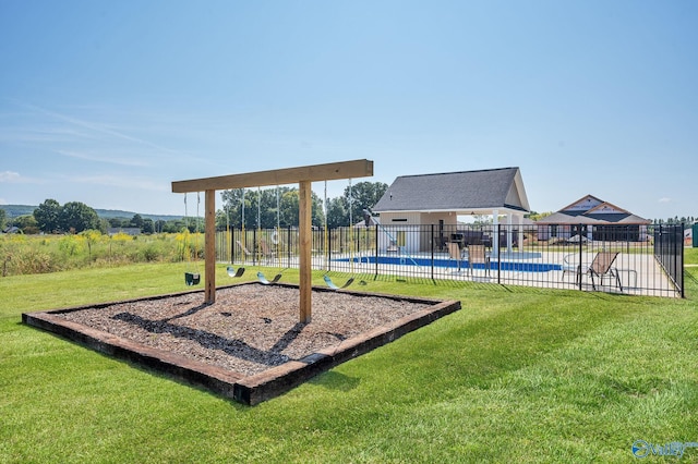 community jungle gym featuring a fenced in pool, fence, and a lawn