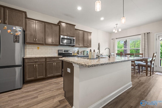 140 Amelia Dr, Harvest, AL 35749 - kitchen with appliances with stainless steel finishes, dark brown cabinets, dark wood-type flooring, tasteful backsplash, and light stone countertops