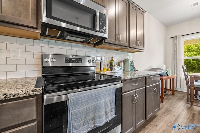 140 Amelia Dr, Harvest, AL 35749 - kitchen featuring stainless steel appliances, dark brown cabinetry, light wood finished floors, and decorative backsplash