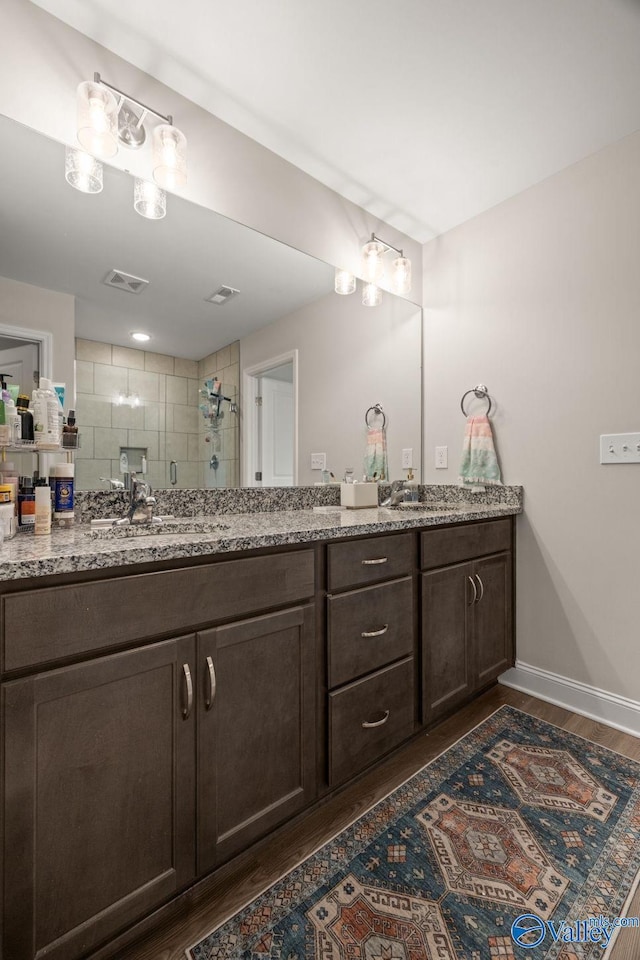 140 Amelia Dr, Harvest, AL 35749 - full bath featuring wood finished floors, a stall shower, double vanity, and baseboards