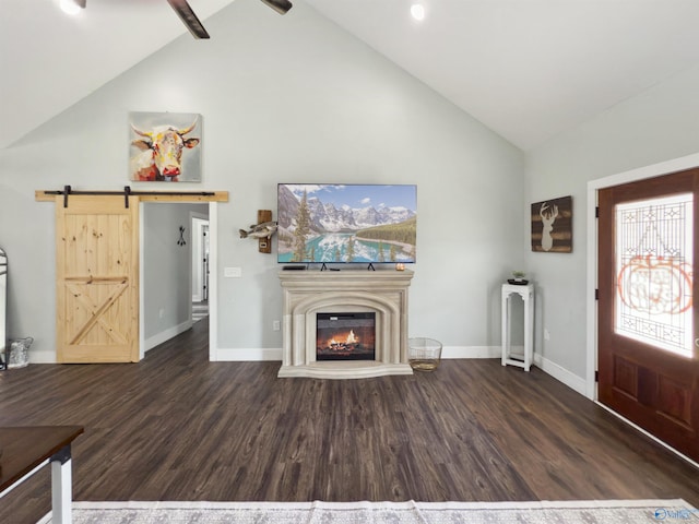 unfurnished living room with beam ceiling, a barn door, dark hardwood / wood-style flooring, and high vaulted ceiling