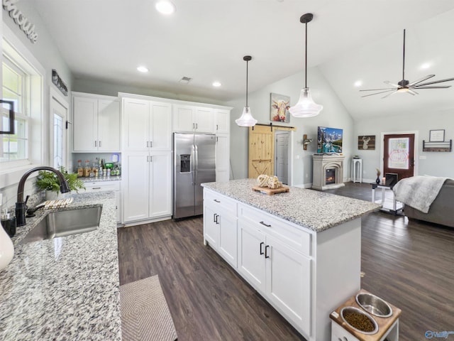 kitchen featuring white cabinets, sink, dark hardwood / wood-style flooring, pendant lighting, and stainless steel refrigerator with ice dispenser