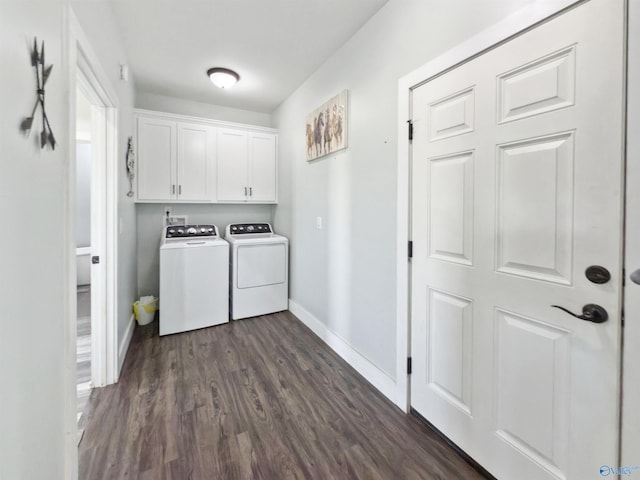 laundry room with dark wood-type flooring, washing machine and dryer, and cabinets