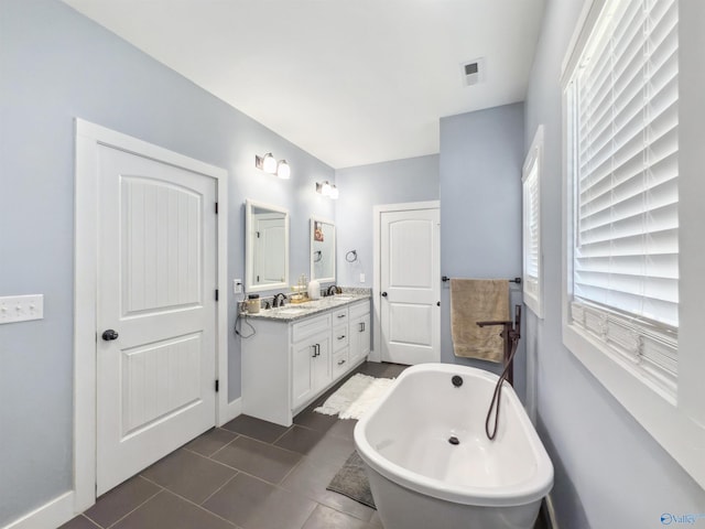 bathroom with tile patterned flooring, a bath, and vanity