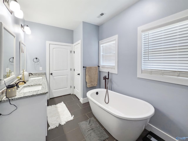 bathroom featuring vanity, a bathing tub, and tile patterned flooring